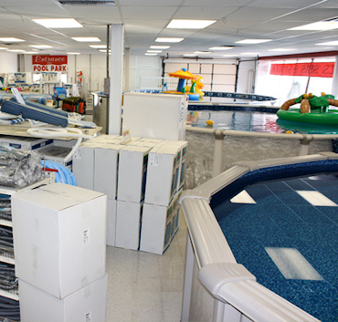 Wide view of the full showroom floor from the entrance, showing pools, spas, and accessories