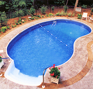 Kidney-shaped in-ground pool nestled into a gently sloped backyard