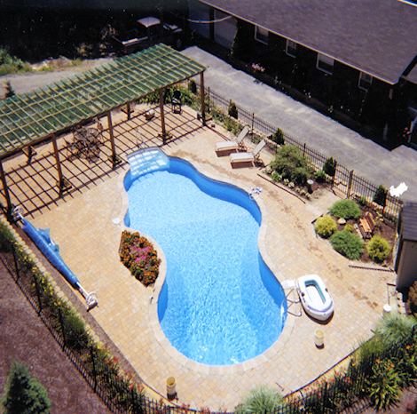 Backyard vinyl liner pool with diving board and poolside landscaping
